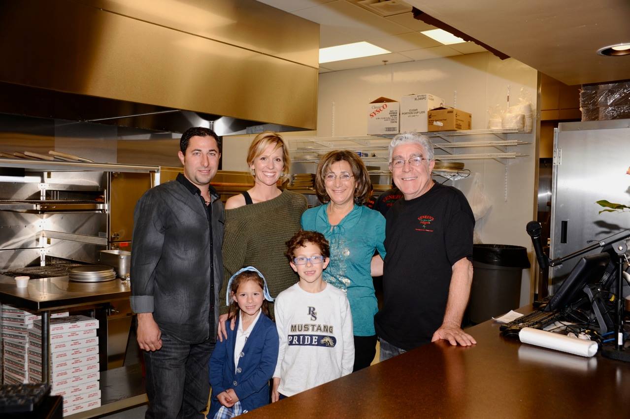 Owner Domenick and his family standing in the restaurant
