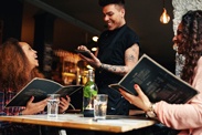 A waiter taking an order on a tablet